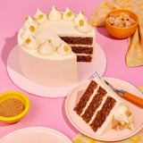 Classic Carrot Cake by Crumbs & Doilies with three moist layers and smooth cream cheese icing decorated with crystallised ginger